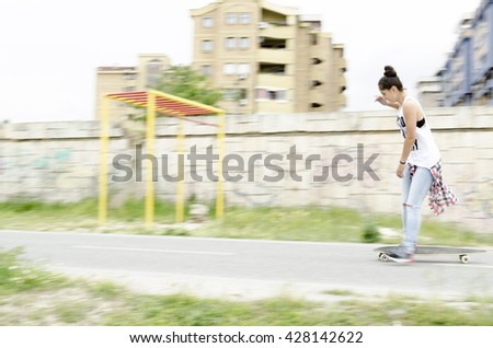 Beautiful young woman driving skateboard.