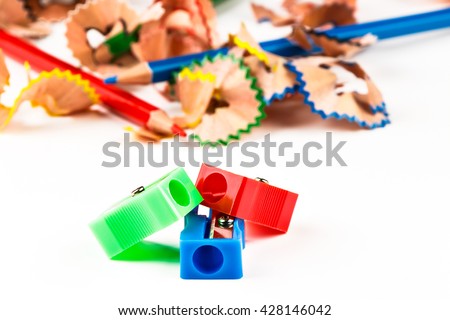 Red, green and blue pencil sharpener with color shavings pencils. Horizontal image.