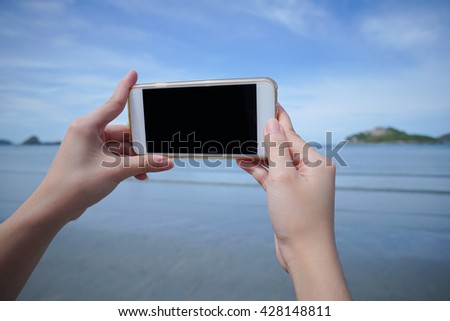 woman use smart phone take a photo of the sea in Prachuapkhirikhan ,thailand isolate black monitor
