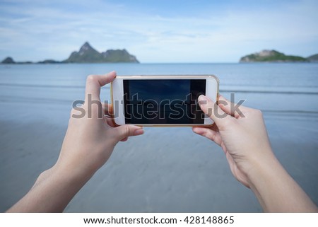 woman use smart phone take a photo of the sea in Prachuapkhirikhan ,thailand real picture in monitor