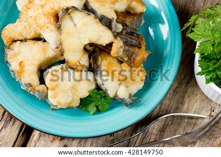 Fried fish sea rabbit (chimera fish, sea rat) on wooden table top view