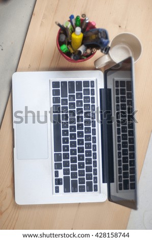 laptop with pen holder and empty mug