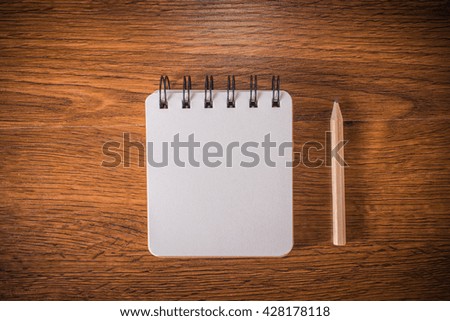 Wood table with  notebook and pencil