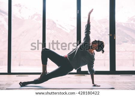 Young beautiful woman practicing yoga with mountain view in the background. Wellness concept. Calmness and relax, woman happiness. Toned picture Royalty-Free Stock Photo #428180422