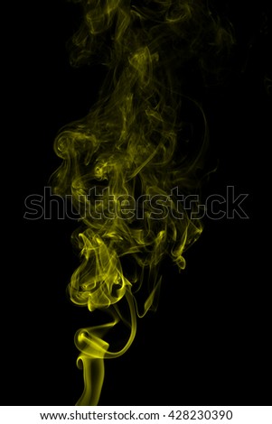 Abstract yellow smoke on black background from the incense sticks