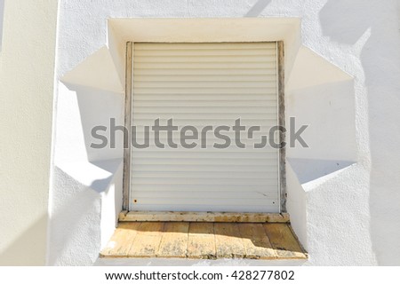 Window with metal roller shutter on the beautiful old wall background outdoors