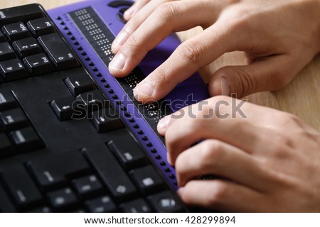 Blind person using computer with braille computer display and a computer keyboard. Blindness aid, visual impairment, independent life concept.
 Royalty-Free Stock Photo #428299894
