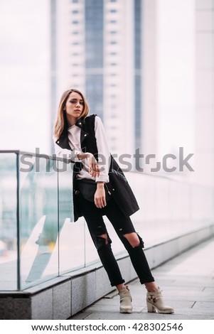 The concept of street fashion. Young beautiful model in the city urban background,fashion look