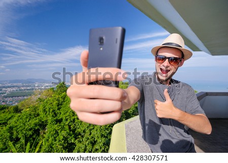 Tourist attraction. Traveler taking selfie with smartphone camera on the view point enjoying sea, city and sky.