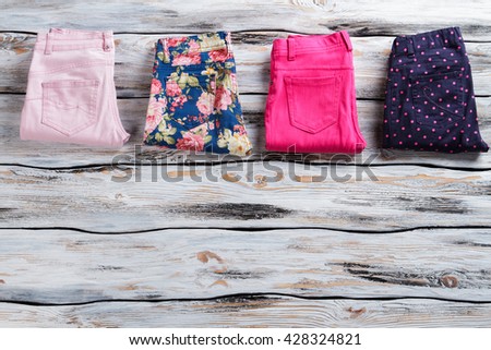 Lady's different color trousers. Navy and light pink pants. Attractive discounts at clothing store. Time to go shopping.