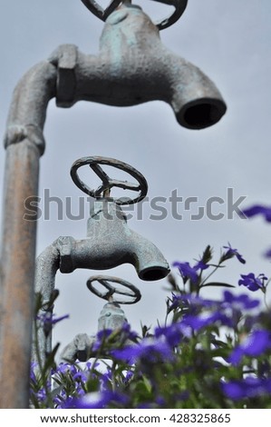  Low-angle view of rusty faucets painted patina. Selective focus.