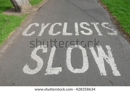 Bike path information. White painted letters on a road. 