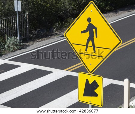 Sign warning of pedestrian crossing and crosswalk in California. Selective focus on sign.
