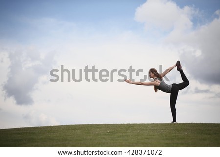 Yoga woman in park. Woman training in urban park at sunset intentional sun glare. Photo of sporty woman doing yoga with nature.