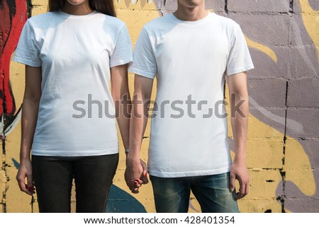 Young man and girl in white T-shirts standing on the street Royalty-Free Stock Photo #428401354