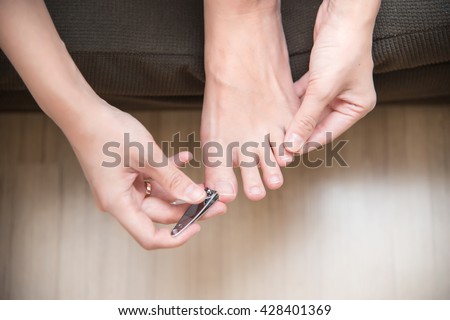 closeup of a woman cutting nails Royalty-Free Stock Photo #428401369