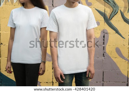 Young man and girl in white T-shirts standing on the street Royalty-Free Stock Photo #428401420