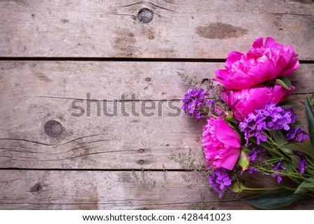 Pink peonies flowers on aged wooden background. Flat lay. Top view with copy space. Selective focus.
