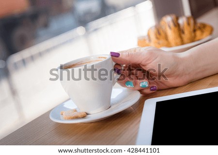 View of a woman hand reaching out to take a cup of rich espresso coffee. breakfast with cup of coffee