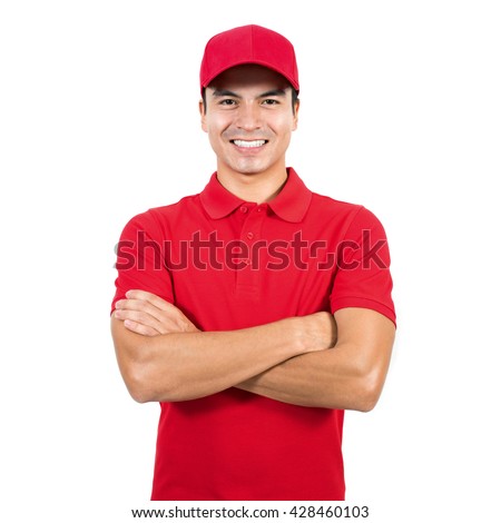 Smiling delivery man in red uniform standing with arm crossed - isolated on white background Royalty-Free Stock Photo #428460103