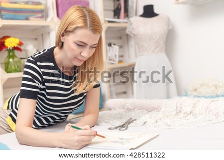 Skillful female tailor is designing bridal gown