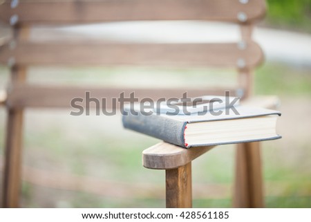 Opened book and phone on table in garden. Outdoor. Summer. Selective focus