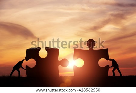 Teamwork concept. Two businessman connecting jigsaw puzzle pieces together with copy space Royalty-Free Stock Photo #428562550