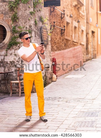 male tourist in the old town taking photo on the phone