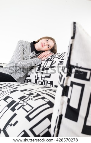 Beautiful attractive girl sitting on modern sofa in white room