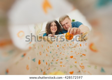 Couple Leaning into Baby Bed Taking Pictures. kind eyes of a child, from crib