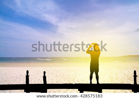Silhouette of man taking photo background sky.Process in vintage color tone