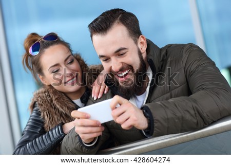 Picture of young couple hanging out in city and texting