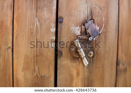 Brown wooden surface with an iron lock. Can be used for design, websites, interior, background, backdrop, texture creation, the use of graphic editors, illustration, to create seamless textures.