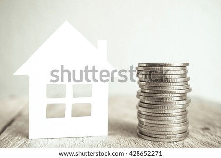 house model and growing plant on row of coin money for finance and banking concept