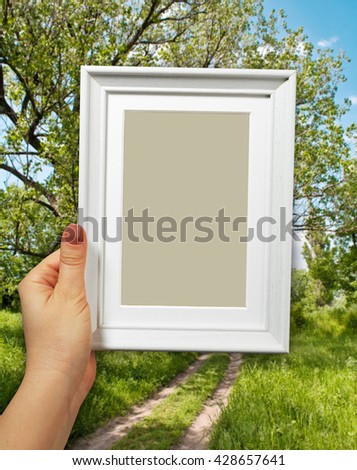 Wooden frame in beautiful woman hands on the forest background