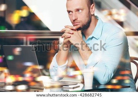 Young businessman having lunch and working in a cafe on blurred background
