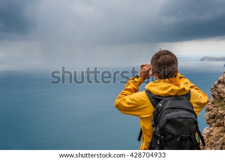 The young man takes pictures of the storm.