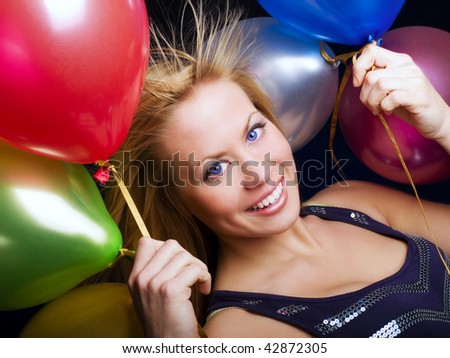 smiling woman holding ballons and celebrating
