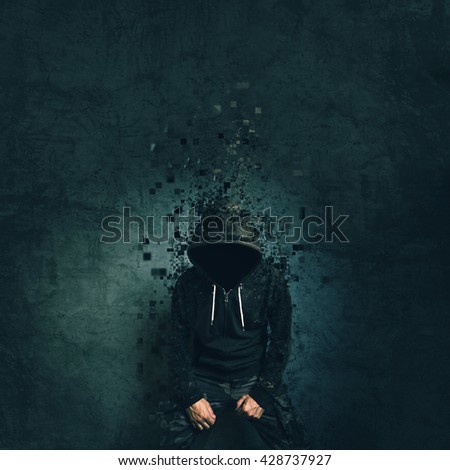 Spooky evil criminal person with hooded jacket dissolving in front of concrete wall.