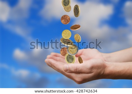 Money rain. Man hands catching falling money from the sky. Photo montage.
