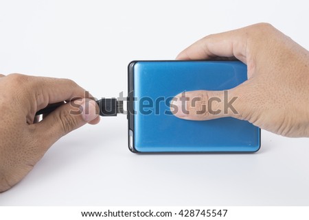 hand connecting cable to external hard drive isolated on white background