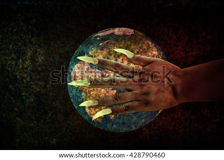 Human hand with long fingernail or devil hand on rusty earth planet with grunge covered,some bad humankind influence world or earth planet ruin,dark side of human (part of picture furnished by NASA)