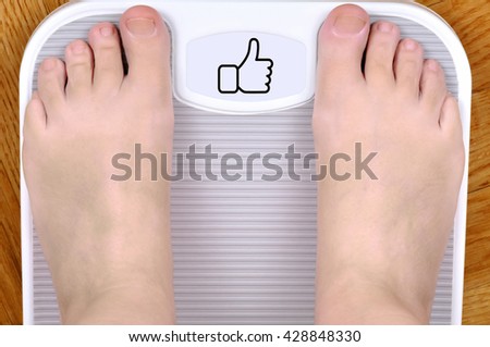 Barefoot person standing on the weight scale. The scale shows like sign