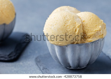 Vanilla Ice Cream with vanilla pods in metal vintage bowl. Homemade Organic product Slate background