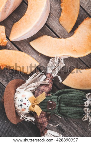pumpkin and scarecrow on a wooden background