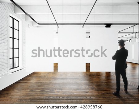 Businessman Modern art museum expo loft interior.Open space studio.Empty white canvas hanging.Wood floor,bricks wall,panoramic windows.Blank frames ready for bussiness information.Horizontal mockup