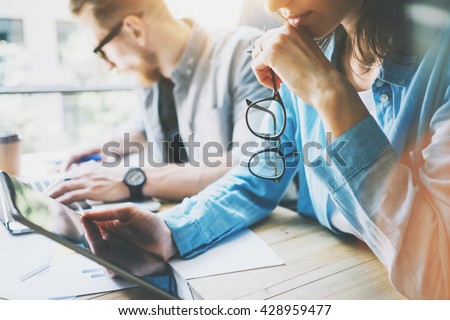 Coworking team brainstorming in modern office.Project Manager Researching Process,holding Glasses Female Hand.Young Business Crew Working with Startup Studio.Using Digital Tablet.Blurred,film effect Royalty-Free Stock Photo #428959477
