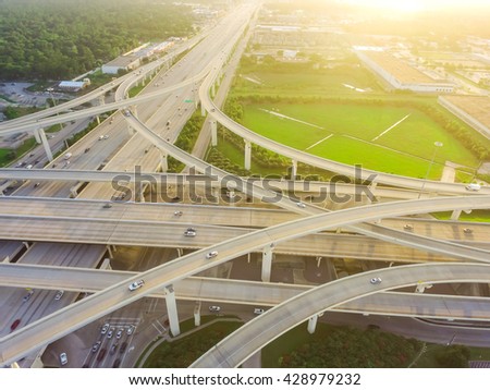 Aerial view massive highway intersection, stack interchange with elevated road junction overpass at late afternoon in Houston, Texas. This five-level freeway interchange carry heavy rush hour traffic.