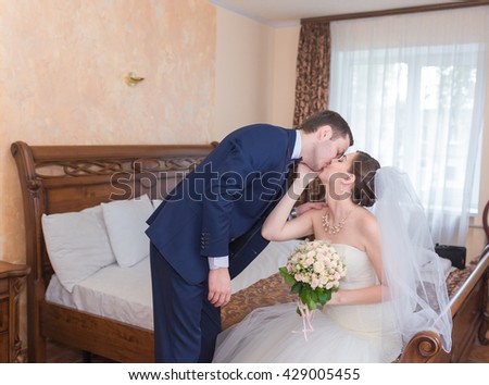 Happy handsome groom with bouquet entering room