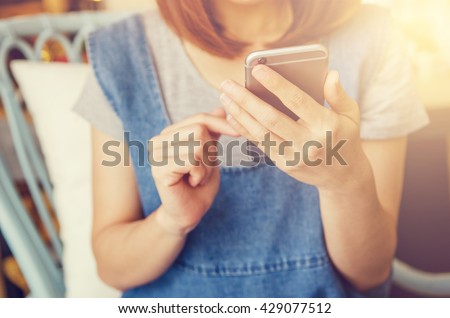 Close up of women's hands holding cell telephone, hipster girl watching video on mobile phone during coffee break.